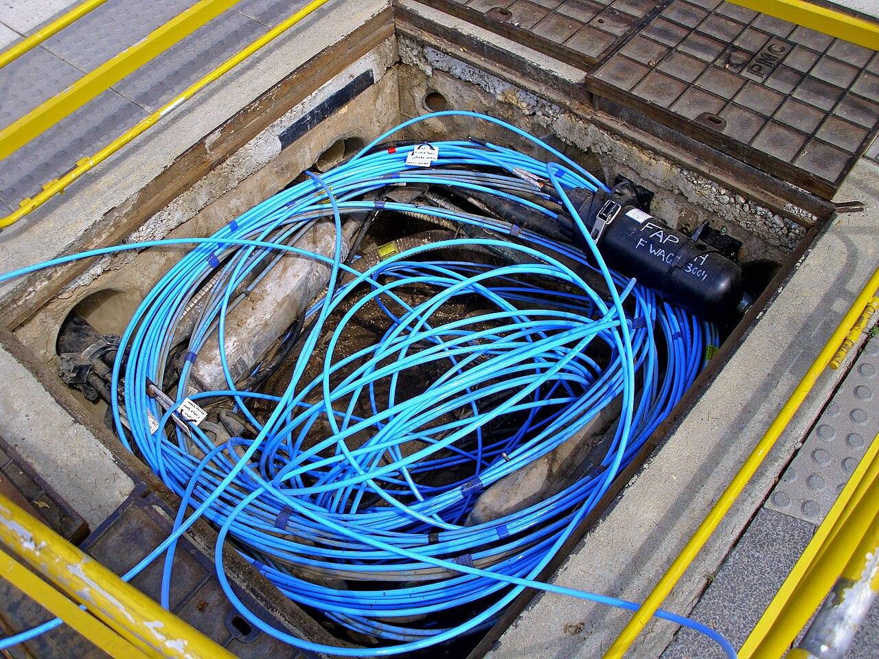 Blown fibre tubes and a joint enclosure coiled in an underground pit