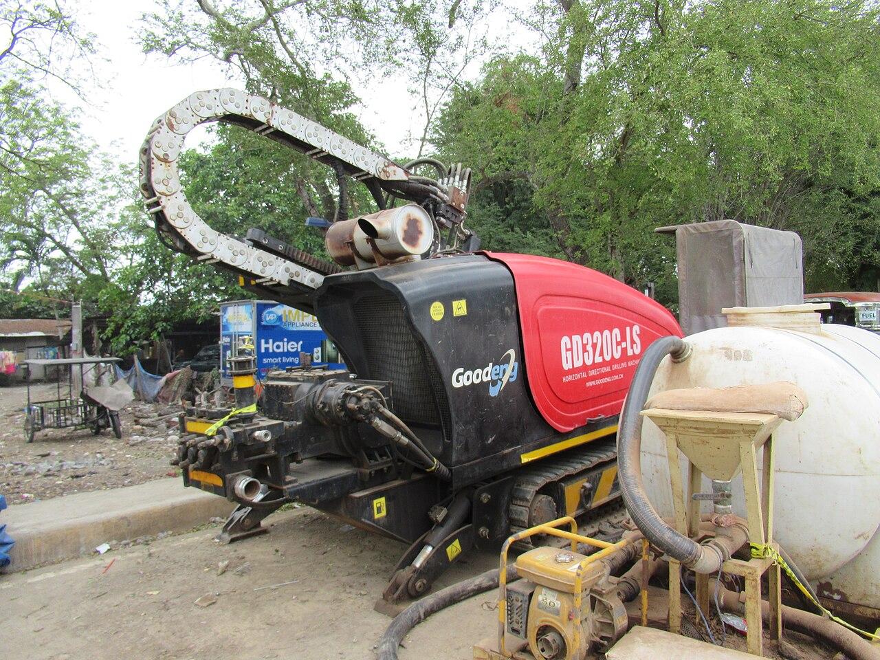 GOODENG horizontal directional drilling rig on a work site, with drill rod rack and cable chain