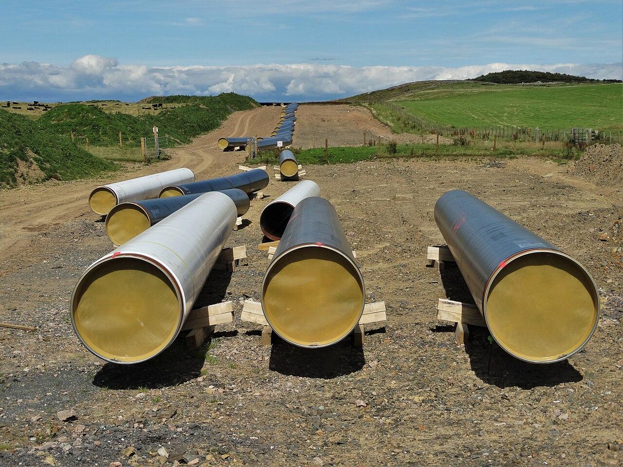 Coated steel pipeline sections strung out along a construction right-of-way